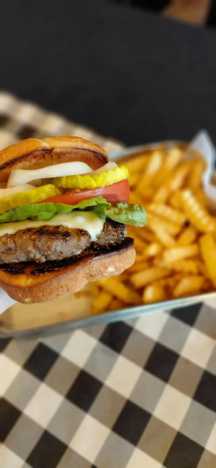 The Original burger, stacked with lettuce, tomato, onion and pickle